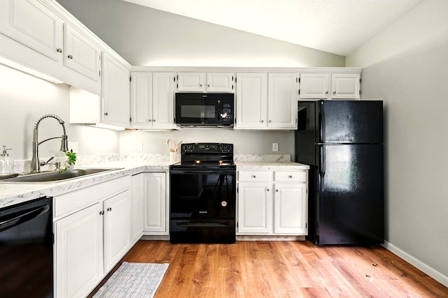 1696 Riva Rdg, Mansfield, OH 44904 - kitchen with black appliances, white cabinetry, vaulted ceiling, and light wood finished floors