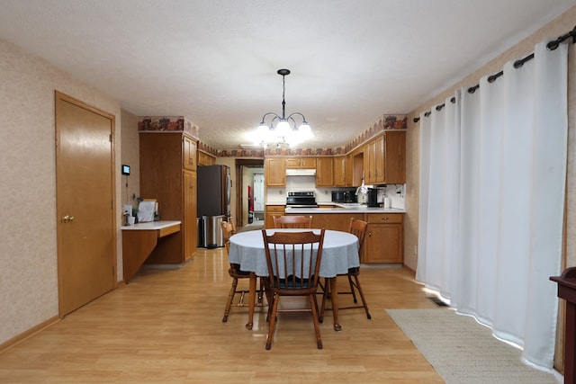 dining room featuring a chandelier, a textured ceiling, light hardwood / wood-style floors, and sink