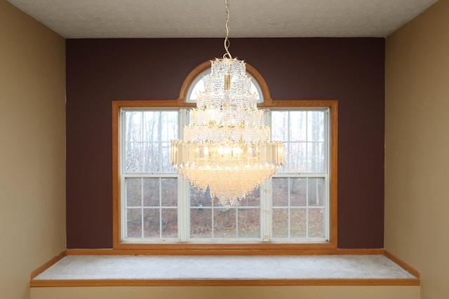 interior details featuring a textured ceiling and an inviting chandelier