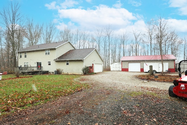 view of home's exterior with a lawn, a garage, and an outdoor structure