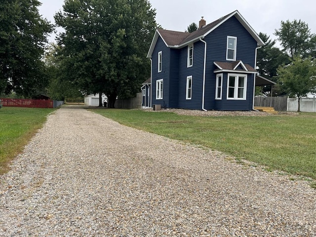 view of side of home featuring a yard, an outbuilding, and a garage