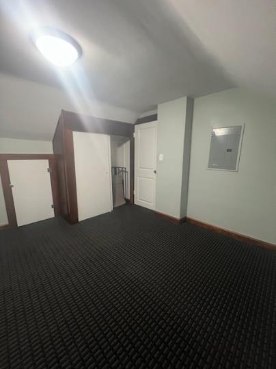 379 S Main St, Mansfield, OH 44902 - additional living space featuring vaulted ceiling, electric panel, dark colored carpet, and baseboards