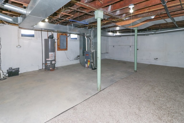 below grade area with heating unit, gas water heater, and electric panel