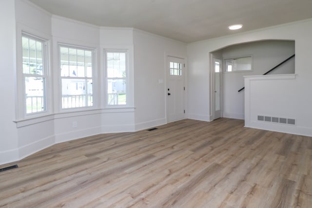 entrance foyer with visible vents, ornamental molding, and wood finished floors