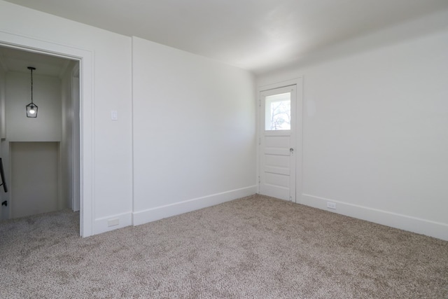 empty room featuring carpet floors and baseboards