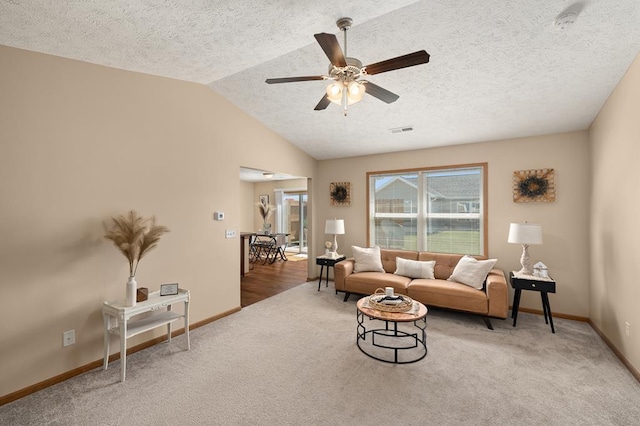 living room featuring a textured ceiling, ceiling fan, vaulted ceiling, and carpet flooring