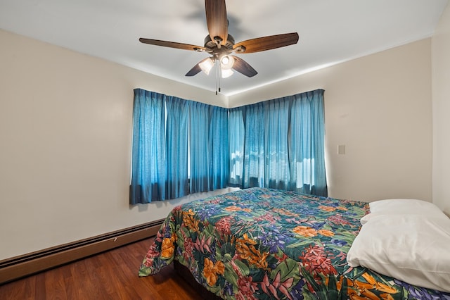 bedroom with ceiling fan, wood-type flooring, and a baseboard heating unit