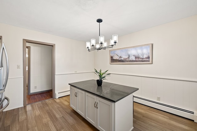 kitchen with baseboard heating, a kitchen island, pendant lighting, and an inviting chandelier