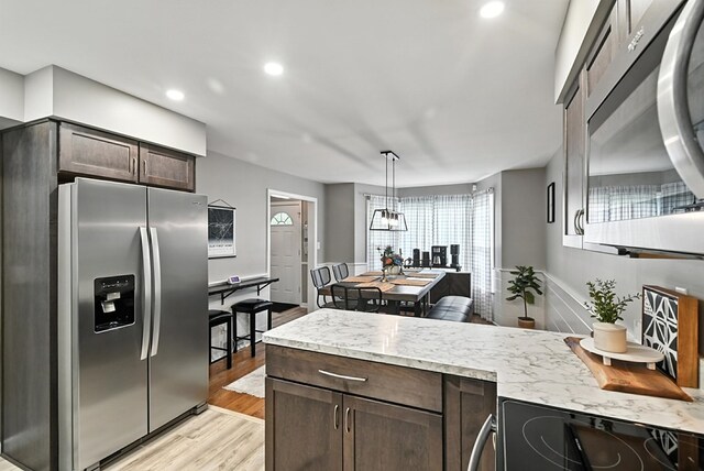 1369 Wilging Dr 1367, Mansfield, OH 44907 - kitchen with appliances with stainless steel finishes, light wood-style flooring, dark brown cabinets, a peninsula, and recessed lighting