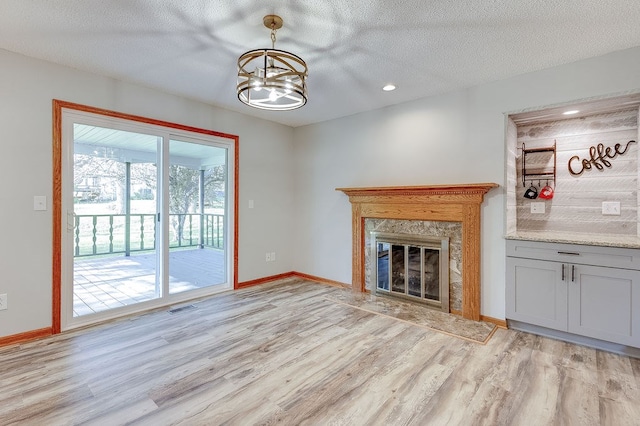 42 Kester Dr, Mount Vernon, OH 43050 - unfurnished living room featuring light wood-style floors, baseboards, a fireplace, a textured ceiling, and recessed lighting