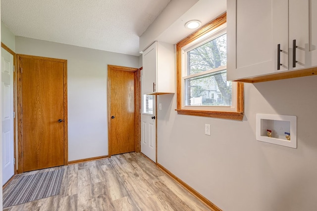 42 Kester Dr, Mount Vernon, OH 43050 - laundry area with cabinet space, hookup for a washing machine, light wood finished floors, a textured ceiling, and baseboards
