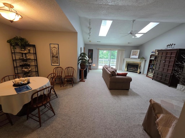 1683 Riva Ridge Dr, Mansfield, OH 44904 - carpeted living area featuring a skylight, lofted ceiling, a glass covered fireplace, a ceiling fan, and a textured ceiling
