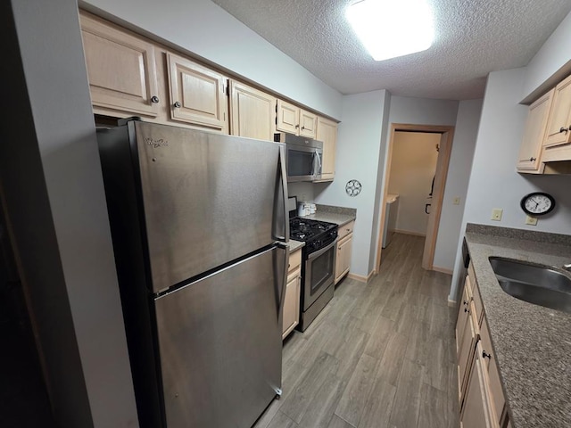 1683 Riva Ridge Dr, Mansfield, OH 44904 - kitchen with stainless steel appliances, a textured ceiling, light wood-type flooring, and dark countertops