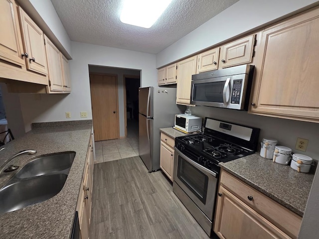 1683 Riva Ridge Dr, Mansfield, OH 44904 - kitchen featuring appliances with stainless steel finishes, a textured ceiling, light wood-style floors, and light brown cabinetry