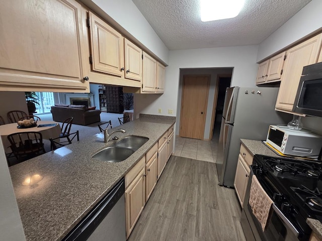 1683 Riva Ridge Dr, Mansfield, OH 44904 - kitchen featuring range with gas cooktop, dishwasher, black microwave, a textured ceiling, and light wood-type flooring