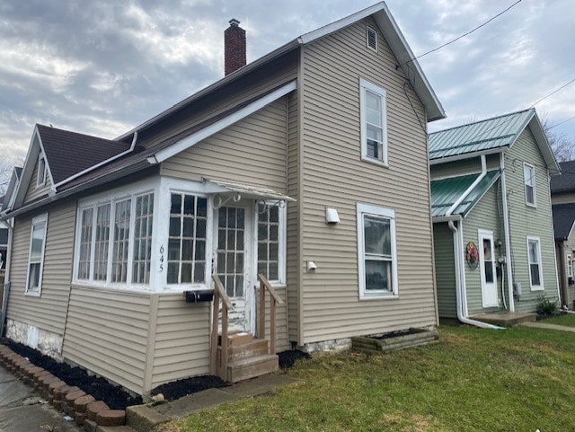 645 Wilson Ave, Marion, OH 43302 - view of home's exterior featuring entry steps, a chimney, and a yard