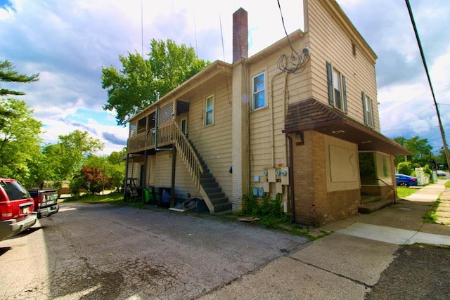 817 E Bowman St, Wooster, OH 44691 - view of side of property featuring stairway, brick siding, and a chimney