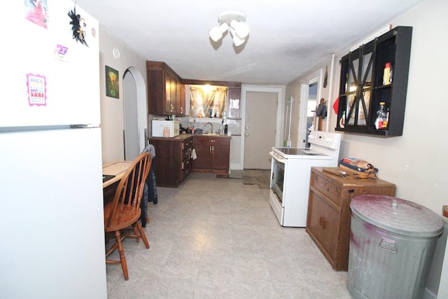 817 E Bowman St, Wooster, OH 44691 - kitchen with white appliances, arched walkways, light floors, and a sink
