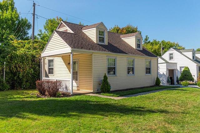 new england style home featuring a porch and a front yard