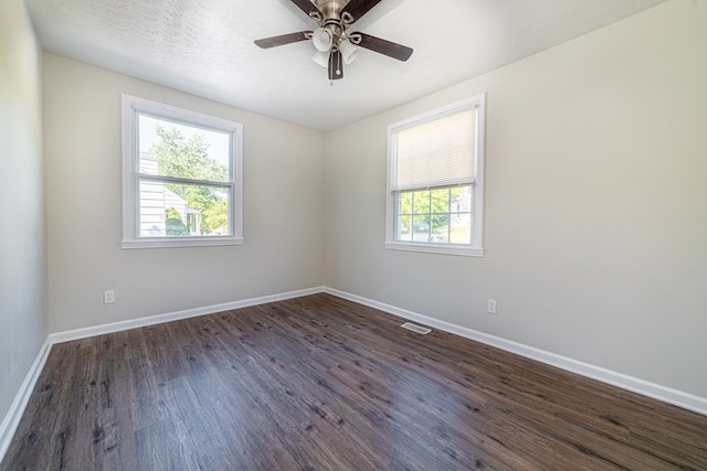 spare room with a textured ceiling, dark hardwood / wood-style flooring, and ceiling fan