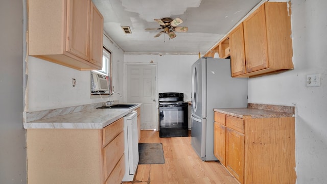 kitchen with electric range, light wood-type flooring, visible vents, a sink, and freestanding refrigerator