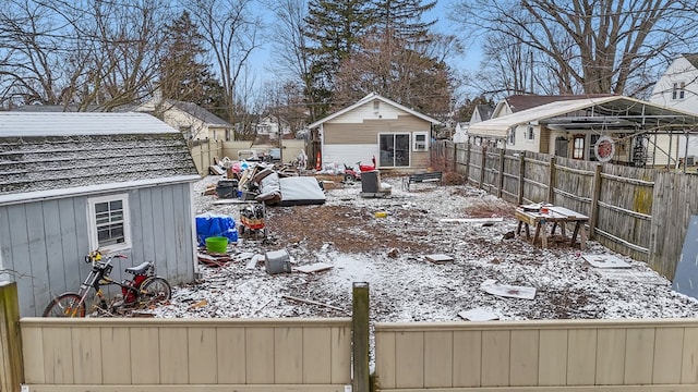 snowy yard with an outdoor structure and a fenced backyard