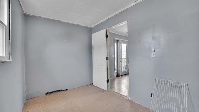 carpeted empty room with a textured ceiling