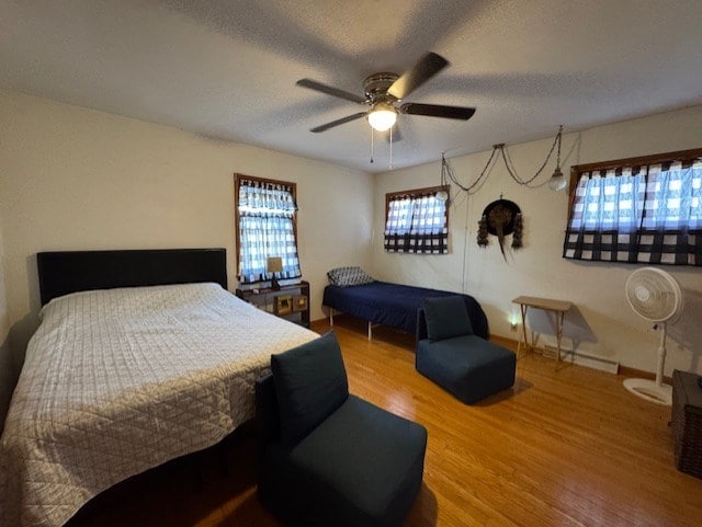 bedroom featuring a textured ceiling, ceiling fan, and wood finished floors