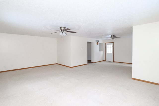 carpeted empty room featuring ceiling fan and a textured ceiling