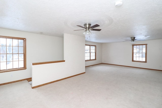 carpeted spare room featuring ceiling fan and a textured ceiling