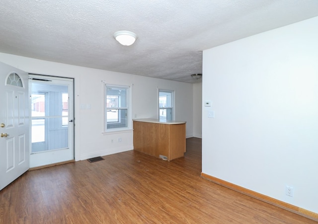 unfurnished room featuring wood-type flooring and a textured ceiling