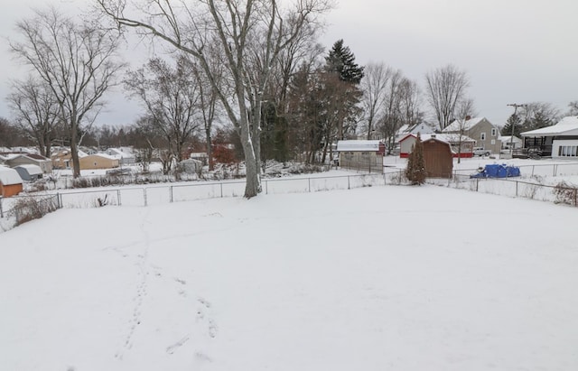 yard layered in snow with a storage shed