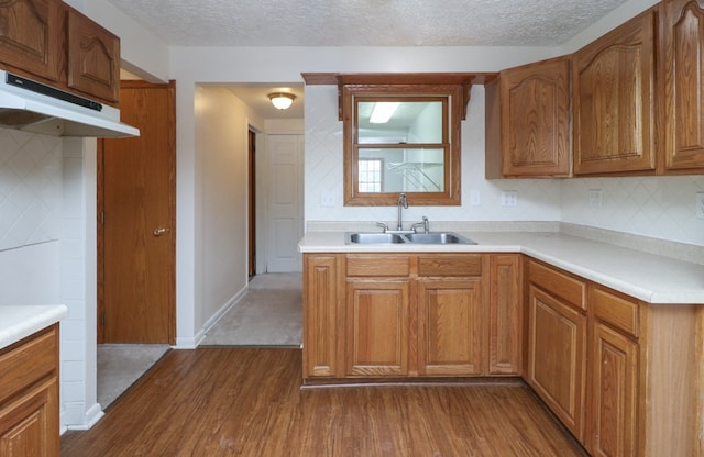 kitchen with a textured ceiling, tasteful backsplash, dark wood-type flooring, and sink