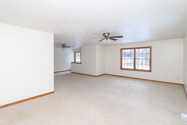 carpeted empty room with ceiling fan and a textured ceiling