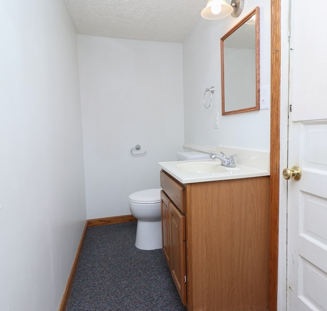 bathroom featuring vanity, a textured ceiling, and toilet