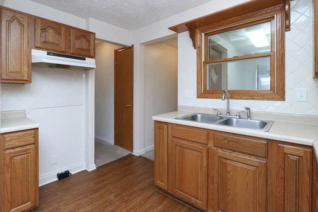 kitchen with decorative backsplash, a textured ceiling, dark hardwood / wood-style flooring, and sink