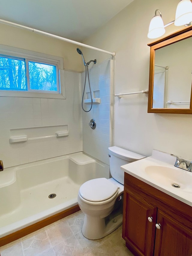 bathroom with vanity, toilet, and a shower