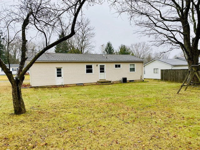 back of property featuring a lawn and central AC