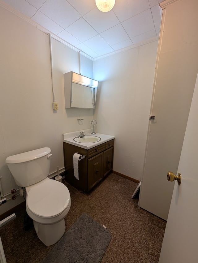 half bathroom with toilet, vanity, and baseboards