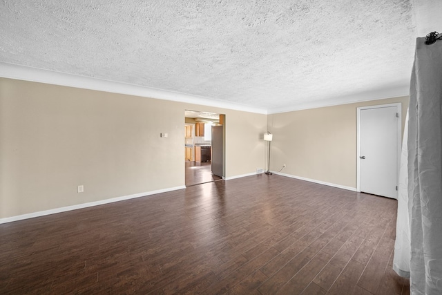 spare room featuring dark wood finished floors, a textured ceiling, and baseboards