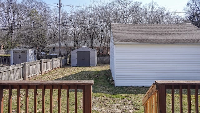 view of yard with a storage unit, an outdoor structure, and fence