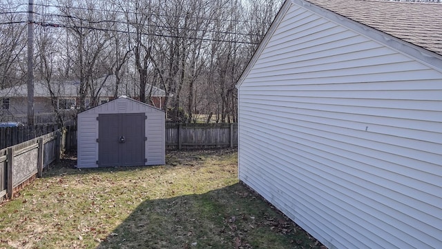 view of yard featuring a storage shed, an outbuilding, and a fenced backyard