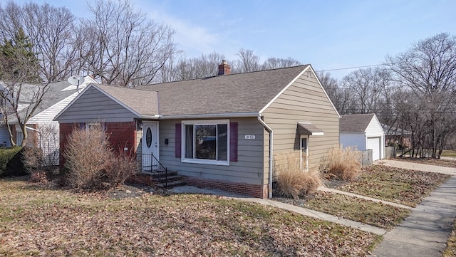 view of front facade featuring an outbuilding, a chimney, a garage, and a shingled roof