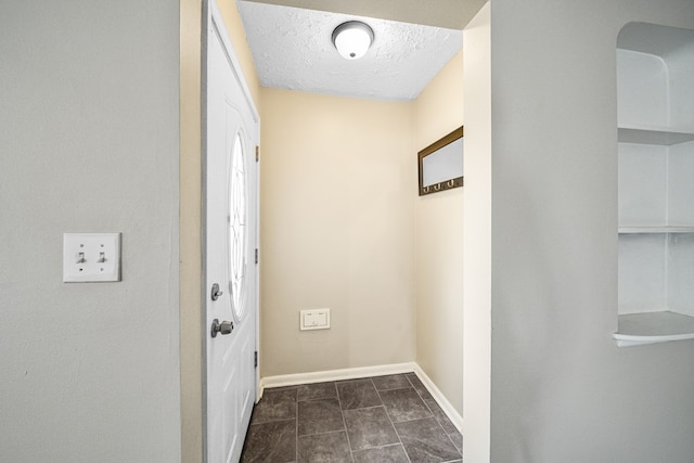 hallway with baseboards and a textured ceiling