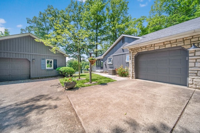 7326 State Route 19 Unit 27-30, Mount Gilead, OH 43338 - view of side of property featuring concrete driveway, a garage, board and batten siding, and stone siding