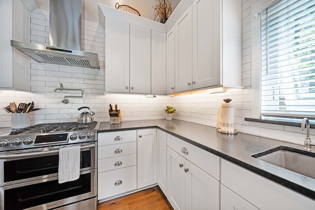 7326 State Route 19 Unit 27-30, Mount Gilead, OH 43338 - kitchen with double oven range, wall chimney range hood, white cabinetry, tasteful backsplash, and wood finished floors
