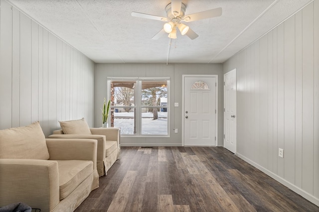 entryway with a textured ceiling, ceiling fan, dark wood-type flooring, and baseboards