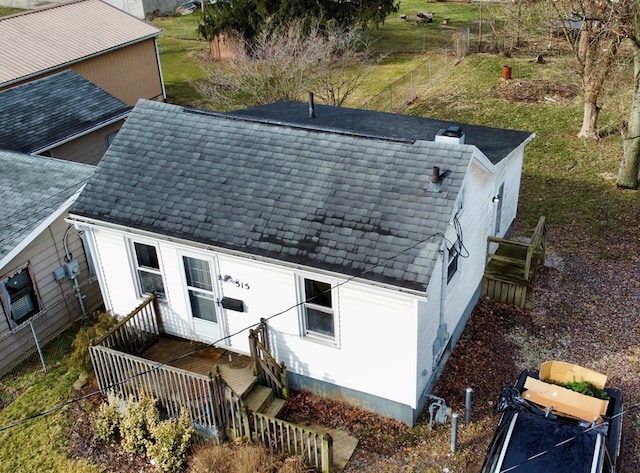 exterior space featuring a shingled roof and fence