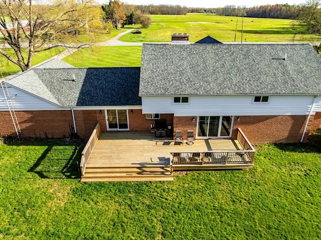 4107 State Route 113, Milan, OH 44846 - back of property featuring a chimney, brick siding, a shingled roof, a wooden deck, and a lawn