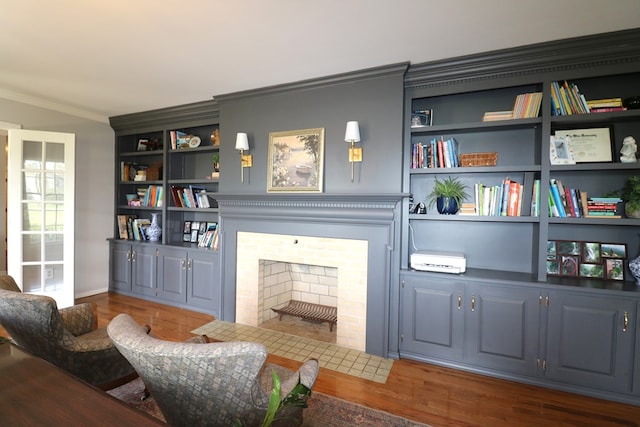 4107 State Route 113, Milan, OH 44846 - living area featuring wood finished floors, built in shelves, baseboards, a fireplace with flush hearth, and crown molding